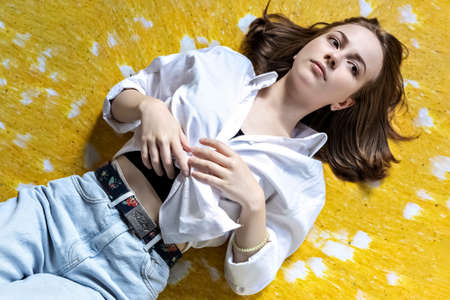 Portrait of a young teenage girl lying on the floor. Stress, depression, relaxation. Mental health.の写真素材