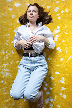 Portrait of a young teenage girl lying on the floor. Stress, depression, relaxation. Mental health.