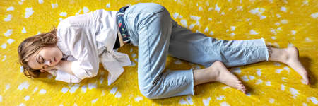 Portrait of a young teenage girl lying on the floor. Stress, depression, relaxation. Mental health.の写真素材