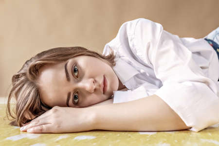 Portrait of a young teenage girl lying on the floor. Stress, depression, relaxation. Mental health.の写真素材