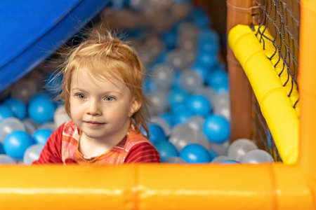 Portrait of a little toddler girl with red hair in a ballroom.の写真素材