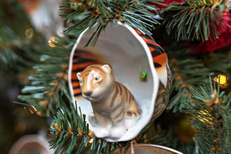 Christmas background of a Christmas tree decorated with Christmas toys with the symbolism of the new year tiger-tiger coloring cup and ball. Winter holidaysの写真素材