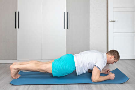 A strong, healthy man with muscles, training at home. fitness at home. Yoga.の写真素材