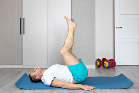 A strong, healthy man with muscles, training at home. fitness at home. Yoga.の写真素材