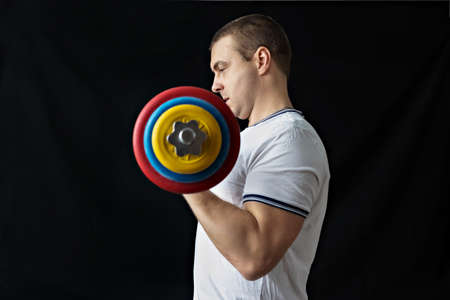 A strong, healthy man with muscles, training at home with a barbell. fitness at homeの写真素材