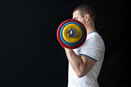 A strong, healthy man with muscles, training at home with a barbell. fitness at homeの写真素材