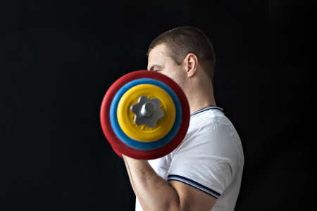 A strong, healthy man with muscles, training at home with a barbell. fitness at homeの写真素材