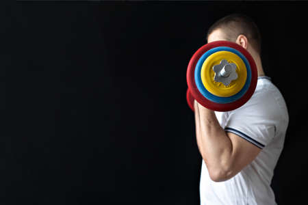 A strong, healthy man with muscles, training at home with a barbell. fitness at homeの写真素材