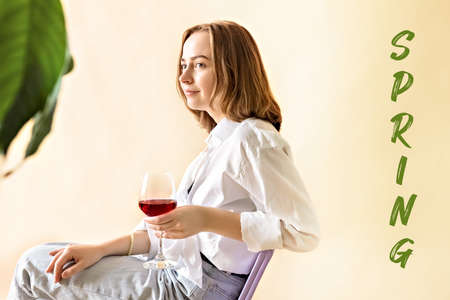 Portrait of a young woman with a glass of red wine in her hands. Spring. Mood.の写真素材