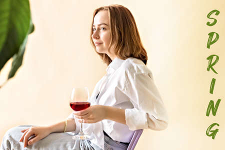Portrait of a young woman with a glass of red wine in her hands. Spring. Mood.の写真素材