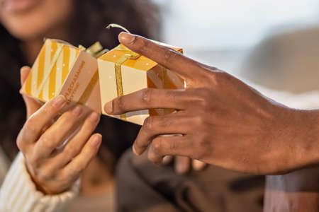 A happy couple exchange gifts with each other. Celebrating joint family events