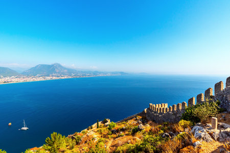 Coast of the Mediterranean Sea with the ruins of a stone wall in the city of Alanya, Turkeyの写真素材