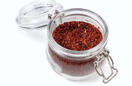 Dry red peppers in a glass jar isolated on a white background.の写真素材