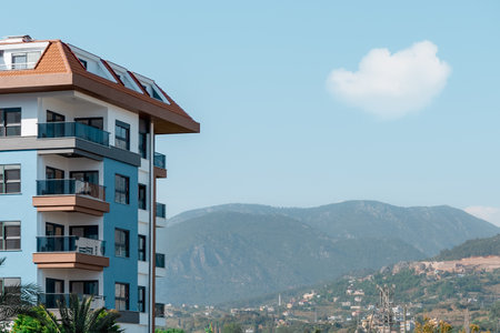 Part of an apartment building against the backdrop of a mountain and blue sky in Turkey.の写真素材