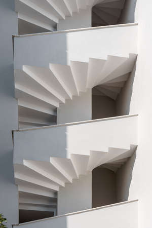 White spiral staircase on the facade of the house. abstract architectural background.