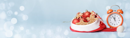 Conceptual photo of meeting the new year, alarm clock and Christmas tree decorations in Santas hat...