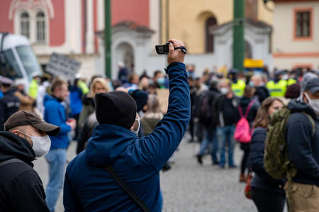 police officers supervise a crowd of people during a demonstration against government measures in...