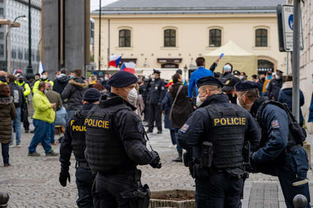 Police officers oversee a crowd of people demonstrating against government measures in the center of...