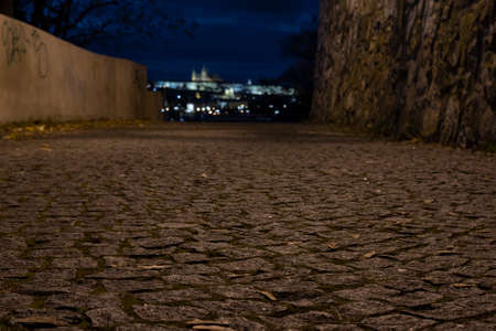 light from a glowing lamp on a stone wall from the 15th century at night in the center of Prague