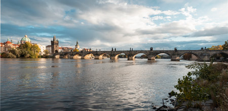 panorama of Charles bridge over Vltava river and blue sky at sunset in the center of Prague and Vltava river during the dayの写真素材