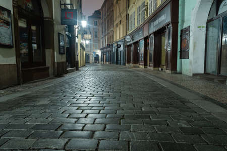 empty illuminated street and cobblestones on the ground in the center of the old town of Prague in lockdown 2021の写真素材