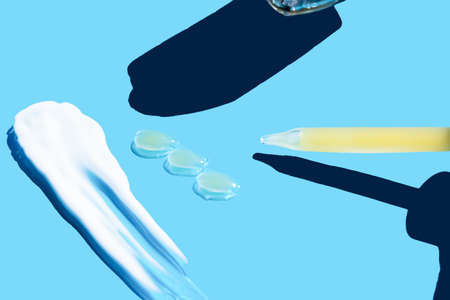Pipette with dose of fluid hyaluronic acid on blue background. cosmetic concept. flat lay. Place for texの写真素材
