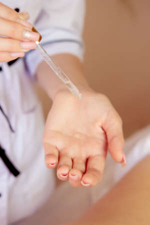 Close-up of masseur's hands pouring fragrant oil on woman's back. The masseuse is preparing for an oriental spa procedure for a relaxing treatment. Therapist makes aromatherapy oil massage on a woman's body.の写真素材