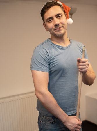 a man in a santa hat holds his hand on a pool table, plays snooker or prepares to shoot billiard...
