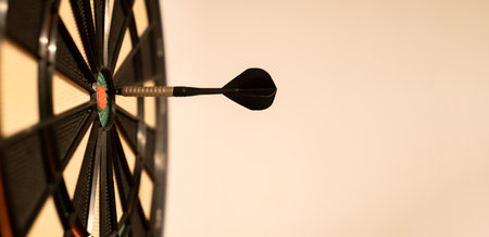 a darts game, an arrow in the center of the target, the target is hit in the center with arrows, isolated on a beige background, gamblingの写真素材