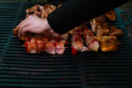 man frying meat skewers on the grill, home food concept