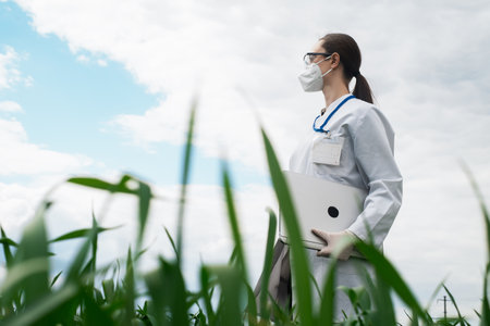 Agronomist using tablet and technology in agricultural corn field. The farmer walks through the field with a tablet. Biologist woman with laptopの写真素材