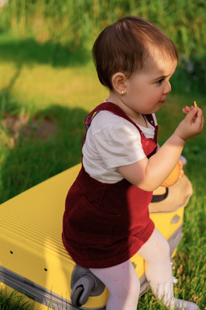 The child sits on a suitcase and, closing his eyes, dreams of travel, adventure, vacation. Little...