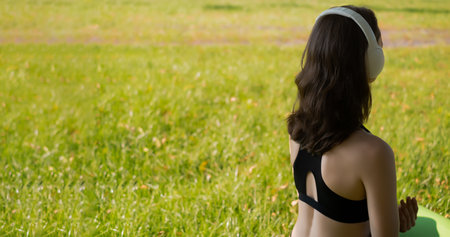a young girl does yoga in a sports uniform, shows elements of sports and asanas. Green park in summer, concept of sport and healthy lifestyle.の写真素材
