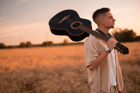 A man with a guitar in the camp. Songs by the fire. Acoustic guitarist in the countryside, musical...
