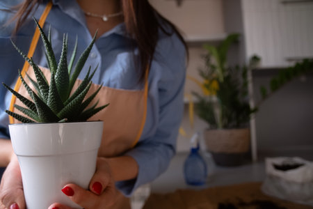 Florist girl takes a selfie with phone, background of flowers and repotting process. Capturing botanical beauty and hands-on plant care.の写真素材
