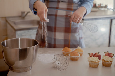 A female pastry chef prepares dough, sprinkling flour, showcasing homemade baking. Explore the charm...