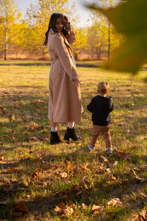 A mother and son stroll through the spring park, enjoying family weekend, celebrating Mother's Day.の写真素材