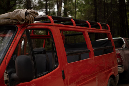 A red open-top tourist bus stands in the forest. Used for tourist agencies, bus tours, excursions, route programs, guides, brochures, and landmarks.の写真素材