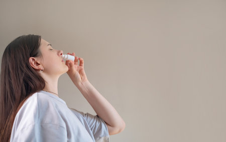 Woman cleansing nasal cavity, hygiene products for nose care, moisturizers and cleansers for nasal passages.の写真素材