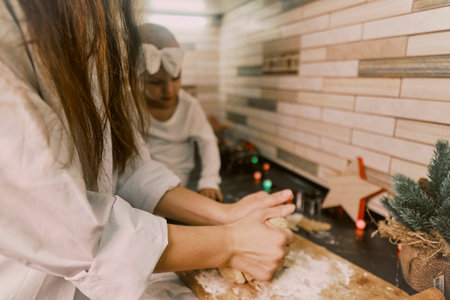 A woman and child baking at home, pastry chef preparing a holiday order, with the child eagerly helping in the kitchen.の写真素材