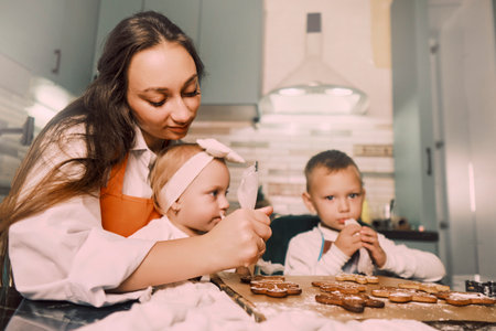 A mother and her children cook together in the kitchen, highlighting how cooking helps develop essential skills in kids.の写真素材