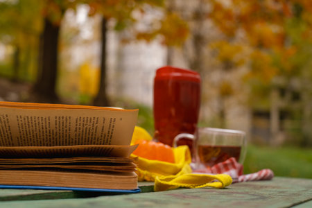 A cozy autumn setting with a cup of hot tea, a pumpkin and a knitted blanket, conveying the atmosphere of autumn.の写真素材