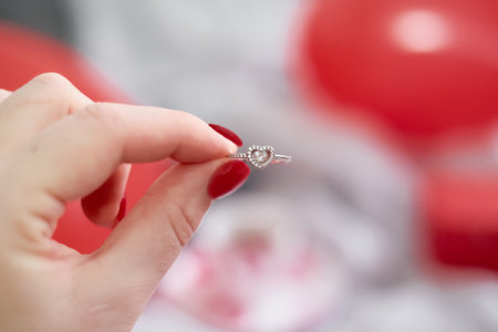A man proposed on Valentine's Day, heart-shaped balloons on the bed, and a woman holds an engagement...
