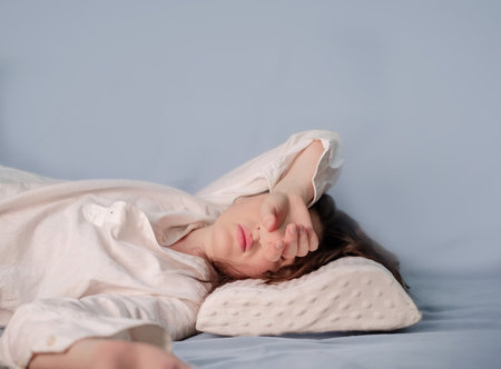 Improving sleep quality with a memory foam pillow, helping with migraines by supporting the head and neck without added strain.の写真素材