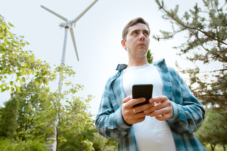 Electrician holding a phone, ensuring reliable power supply and safe operation of electrical systems.の写真素材