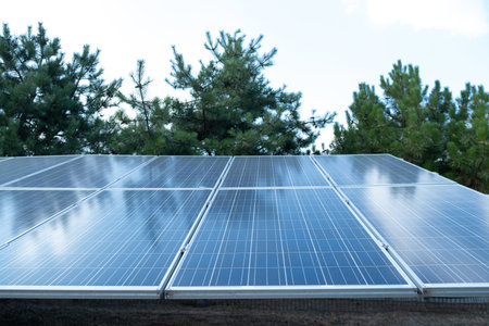 Solar panels against a green park backdrop, generating energy without carbon emissions or harmful substances, reducing environmental impact.の写真素材