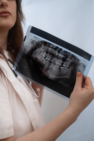 The dentist analyzes an X-ray image to identify inflammatory processes in the jaw and teeth.