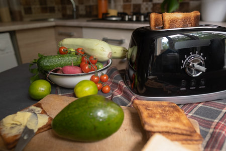 Toast in toaster with various fruits and vegetables on a kitchen counter.
