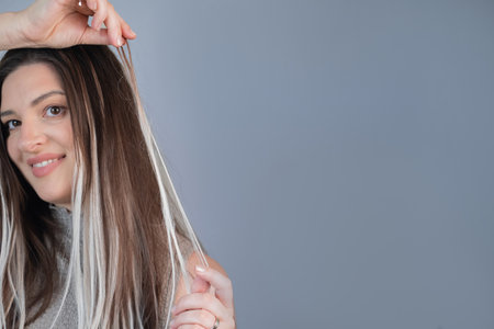 Woman hairstyle after capsule hair extensions showing healthy shiny strands in modern beauty salonの写真素材