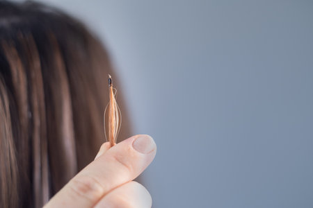 Stylist showing the result of a professional hair extension procedure in a modern beauty salonの写真素材